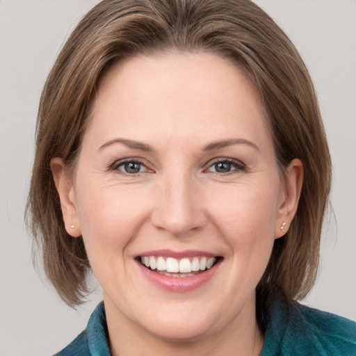 Joyful white adult female with medium  brown hair and grey eyes