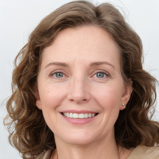 Joyful white adult female with medium  brown hair and green eyes