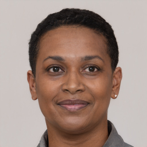Joyful black adult female with short  black hair and brown eyes