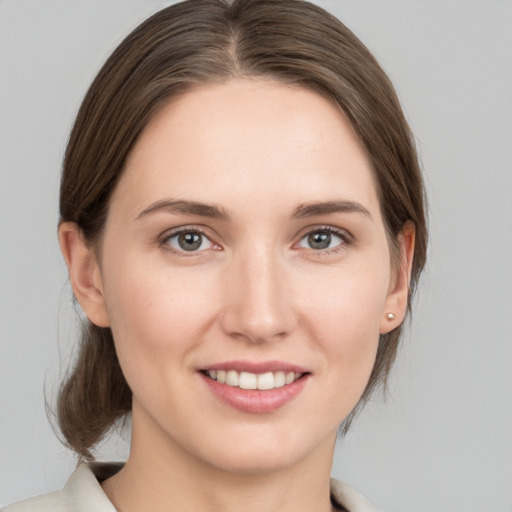 Joyful white young-adult female with medium  brown hair and grey eyes