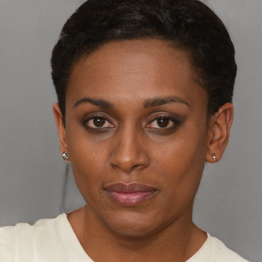 Joyful black young-adult female with short  brown hair and brown eyes