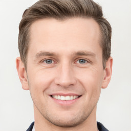 Joyful white young-adult male with short  brown hair and grey eyes