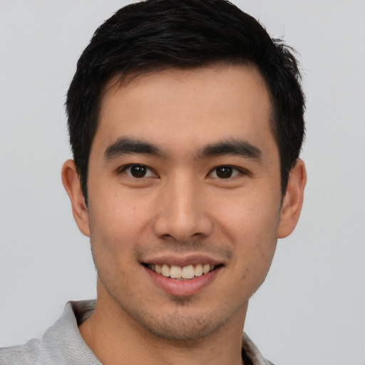 Joyful asian young-adult male with short  black hair and brown eyes