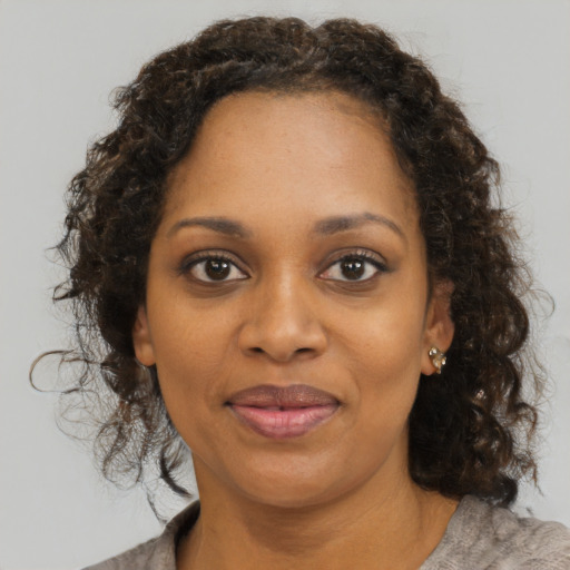 Joyful black young-adult female with medium  brown hair and brown eyes
