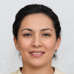 Joyful latino young-adult female with medium  brown hair and brown eyes