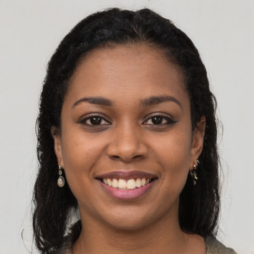 Joyful black young-adult female with long  brown hair and brown eyes