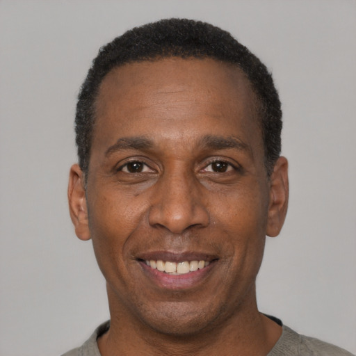Joyful black adult male with short  black hair and brown eyes