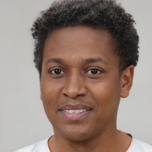 Joyful black young-adult male with short  brown hair and brown eyes
