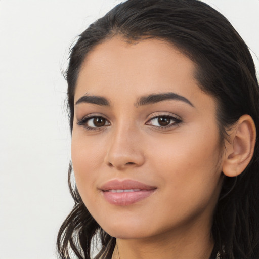 Joyful latino young-adult female with long  black hair and brown eyes