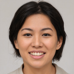 Joyful asian young-adult female with medium  brown hair and brown eyes