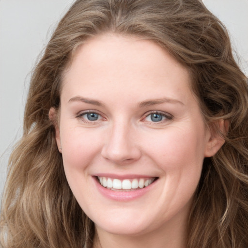 Joyful white young-adult female with long  brown hair and blue eyes