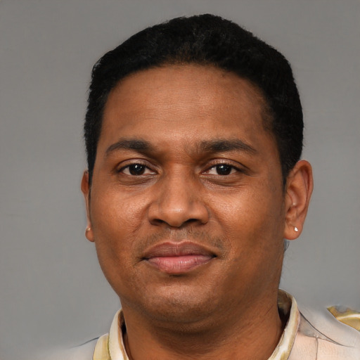 Joyful latino adult male with short  black hair and brown eyes