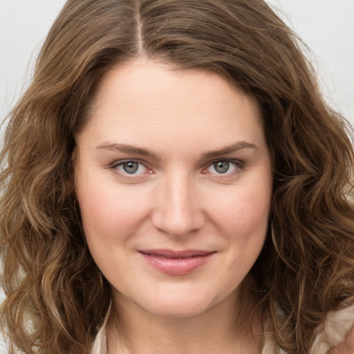 Joyful white young-adult female with long  brown hair and green eyes