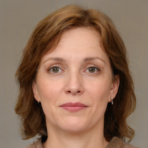 Joyful white adult female with medium  brown hair and green eyes