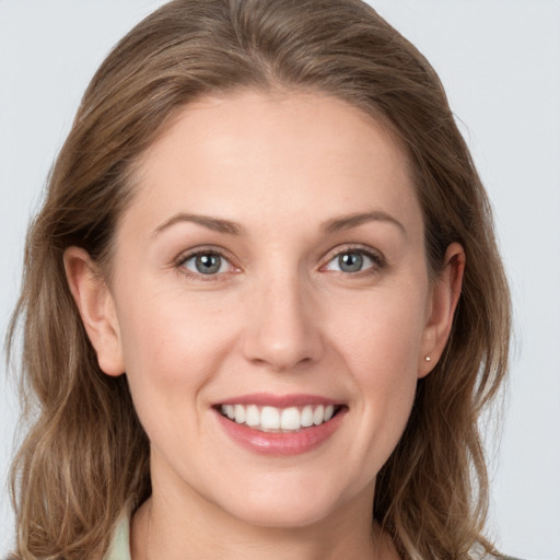 Joyful white young-adult female with long  brown hair and grey eyes