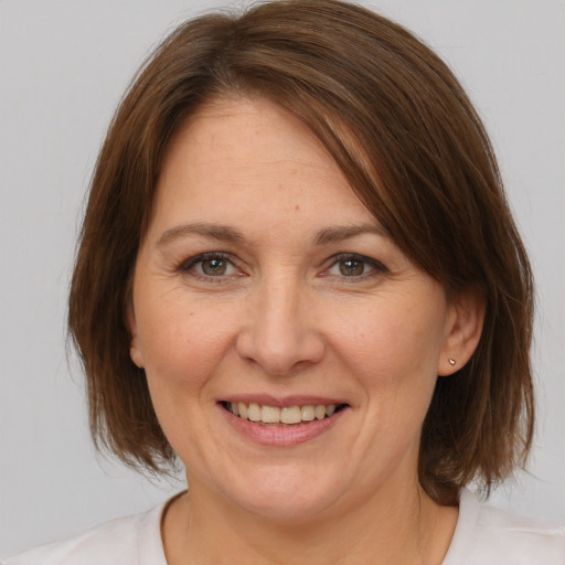 Joyful white adult female with medium  brown hair and brown eyes