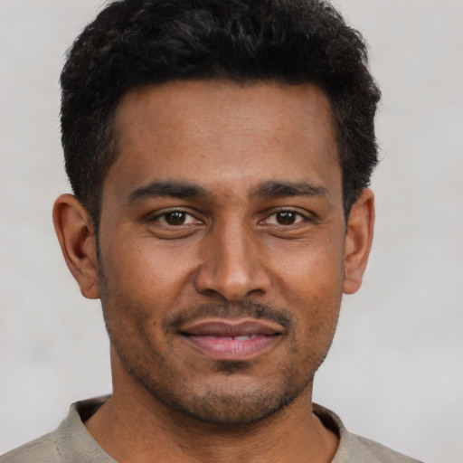 Joyful latino young-adult male with short  brown hair and brown eyes