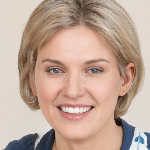 Joyful white young-adult female with medium  brown hair and blue eyes