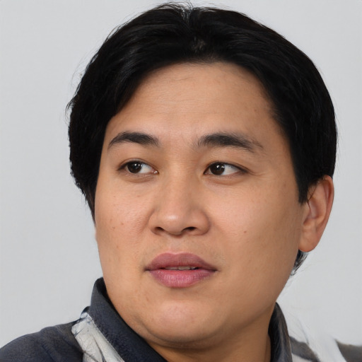 Joyful asian adult male with short  black hair and brown eyes