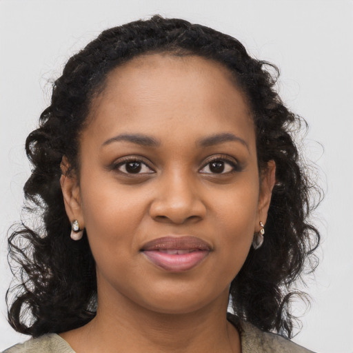 Joyful black young-adult female with long  black hair and brown eyes