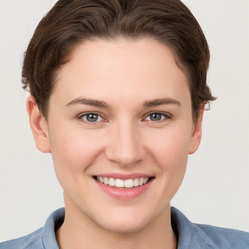 Joyful white young-adult female with short  brown hair and grey eyes