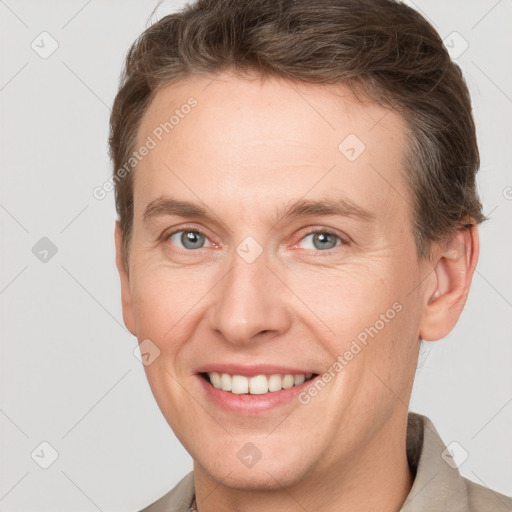 Joyful white adult male with short  brown hair and grey eyes