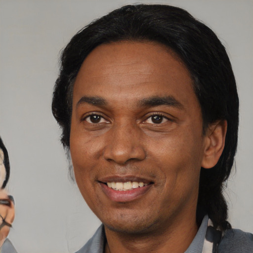 Joyful black adult male with medium  black hair and brown eyes