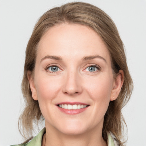 Joyful white young-adult female with medium  brown hair and blue eyes