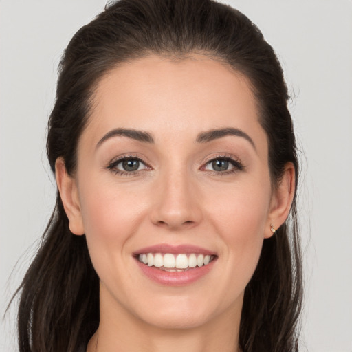 Joyful white young-adult female with long  brown hair and brown eyes