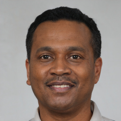 Joyful black adult male with short  black hair and brown eyes