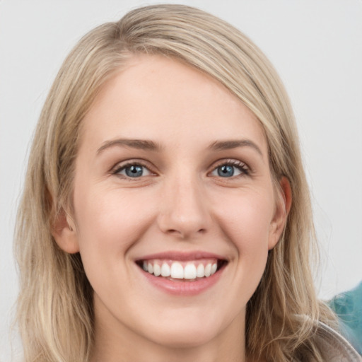 Joyful white young-adult female with long  brown hair and grey eyes