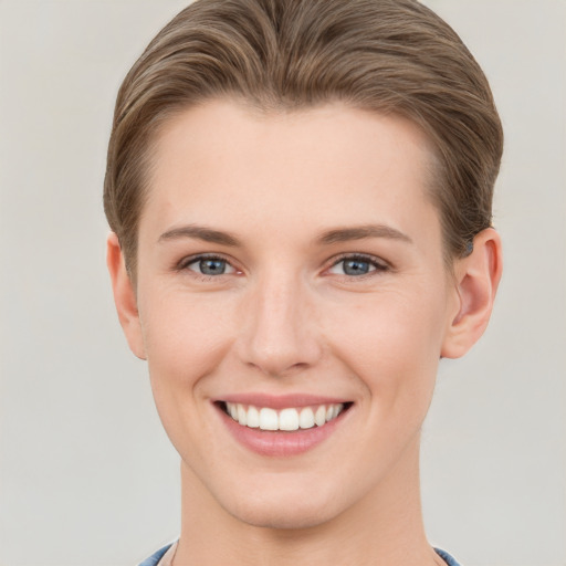 Joyful white young-adult female with short  brown hair and grey eyes