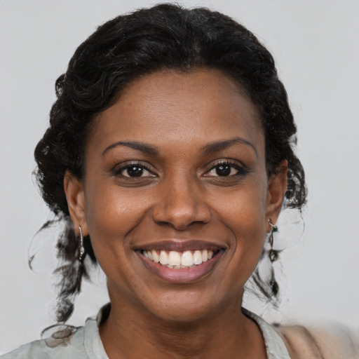 Joyful black young-adult female with medium  brown hair and brown eyes