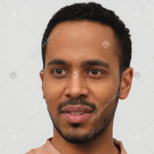 Joyful black young-adult male with short  black hair and brown eyes