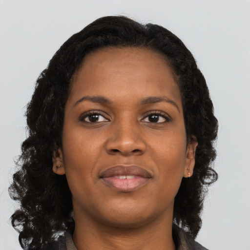 Joyful black young-adult female with long  brown hair and brown eyes