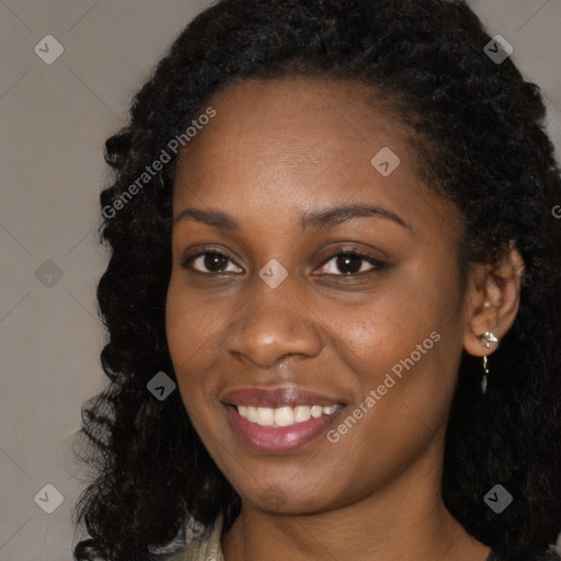 Joyful black young-adult female with long  brown hair and brown eyes