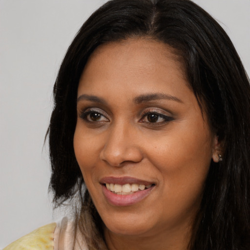 Joyful black young-adult female with long  brown hair and brown eyes