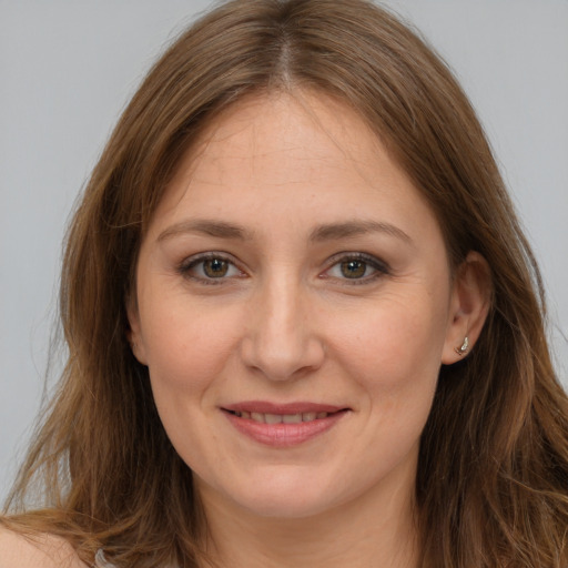 Joyful white young-adult female with long  brown hair and brown eyes