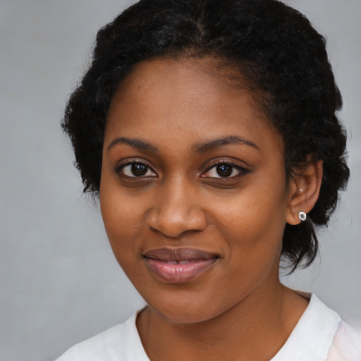 Joyful black young-adult female with medium  black hair and brown eyes