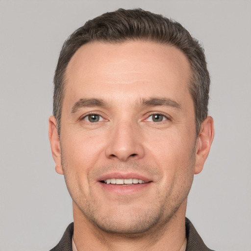 Joyful white adult male with short  brown hair and grey eyes