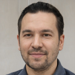 Joyful white adult male with short  black hair and brown eyes