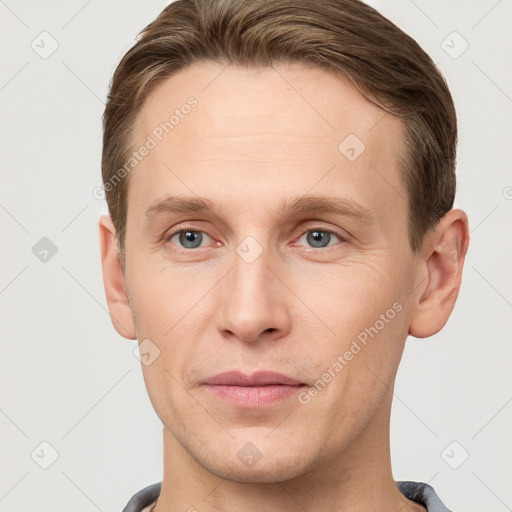 Joyful white young-adult male with short  brown hair and grey eyes