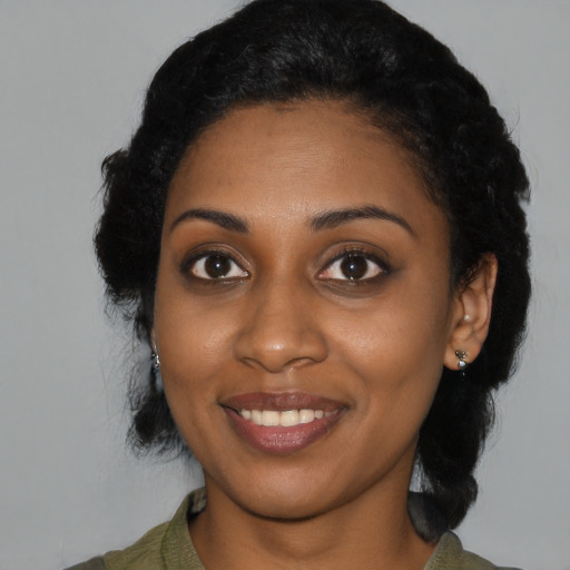 Joyful black young-adult female with medium  black hair and brown eyes