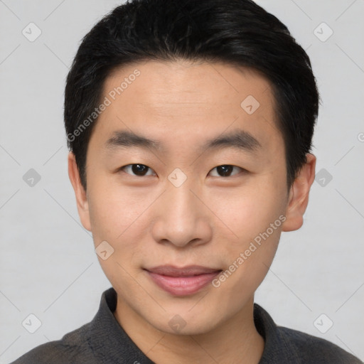 Joyful asian young-adult male with short  black hair and brown eyes