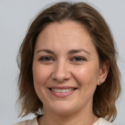 Joyful white adult female with medium  brown hair and brown eyes