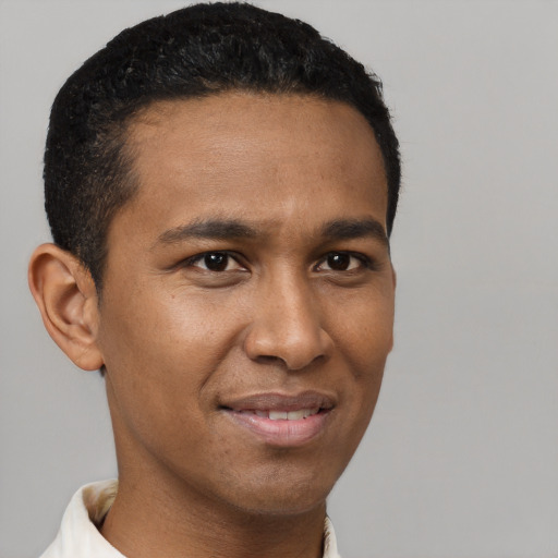 Joyful black young-adult male with short  brown hair and brown eyes