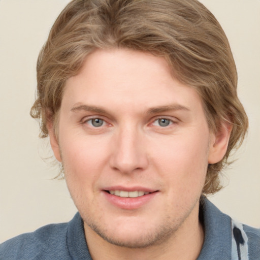 Joyful white young-adult male with medium  brown hair and blue eyes