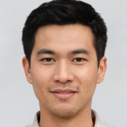 Joyful asian young-adult male with short  black hair and brown eyes