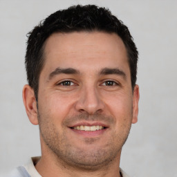 Joyful white young-adult male with short  brown hair and brown eyes