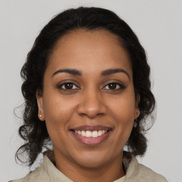 Joyful latino young-adult female with medium  brown hair and brown eyes